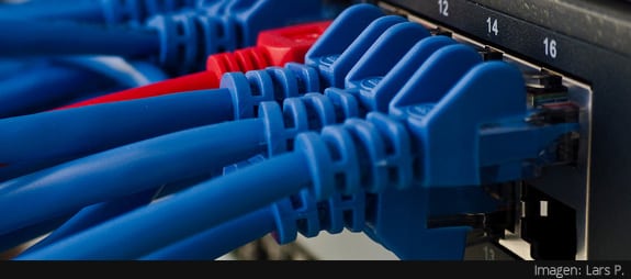Cableado de red: Varios cables azules y uno rojo conectados a un router
